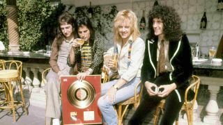 Queen posing for a photograph on a wall in 1975