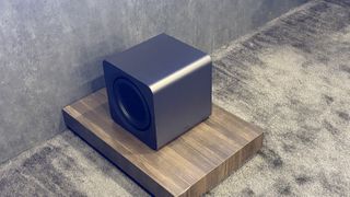 Samsung subwoofer sitting on a wooden platform on the ground