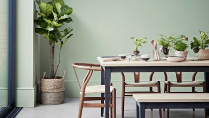 Laid dining table with dinnerware and vase of flowers