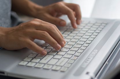 A person typing on a computer keyboard.