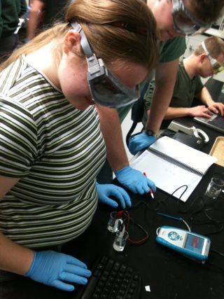 In the laboratory among her peers, a student who is blind uses the differential voltage probe to conduct an electricity experiment with Talking LabQuest.