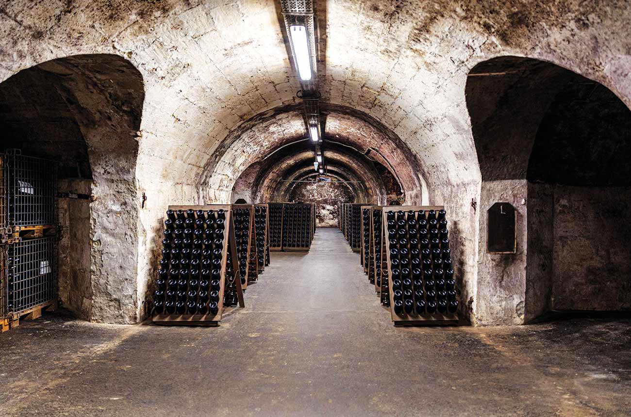 Racks of sparkling wine bottles in a cellar