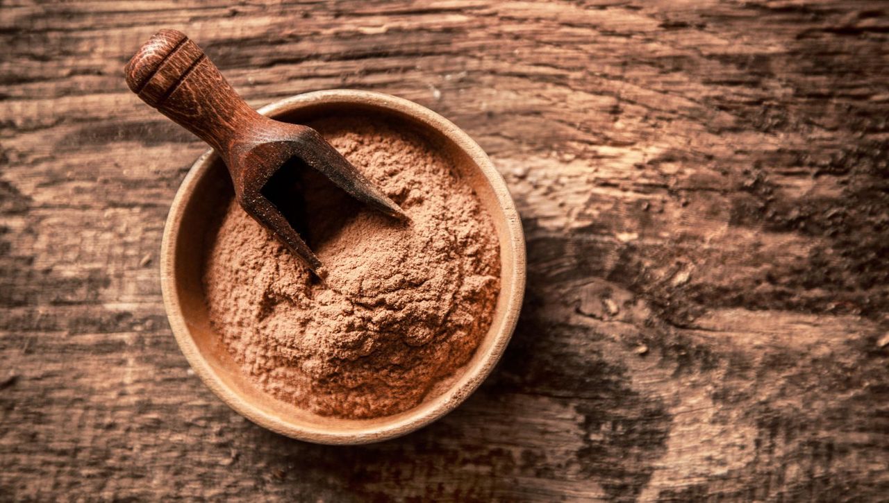 Overhead view of a bowl of finely ground cinnamon powder made from the bark of a tree.