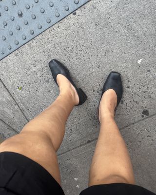 Woman wearing black shorts with black Sam Edelman shoes.