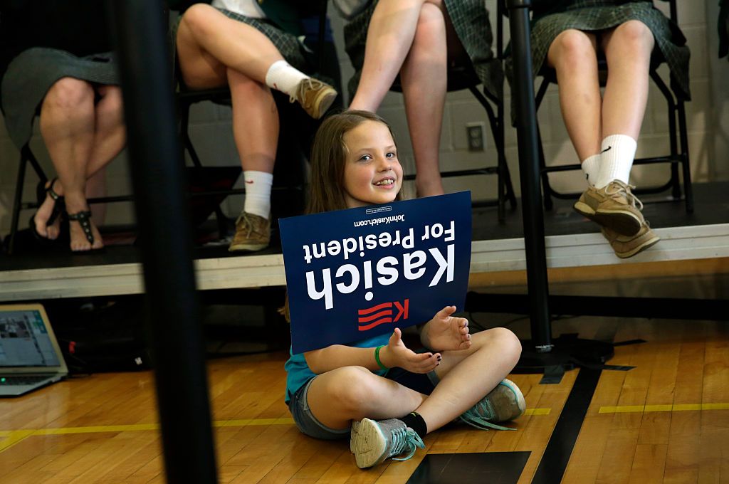 A Kasich supporter in Maryland holds a sign upside-down