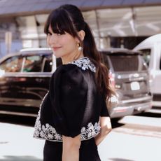 Nina Dobrev looks over her shoulder at the camera while wearing a Carolina Herrera matching set including a beaded crop top and shorts