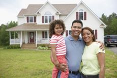 Couple with daughter together in front yard.