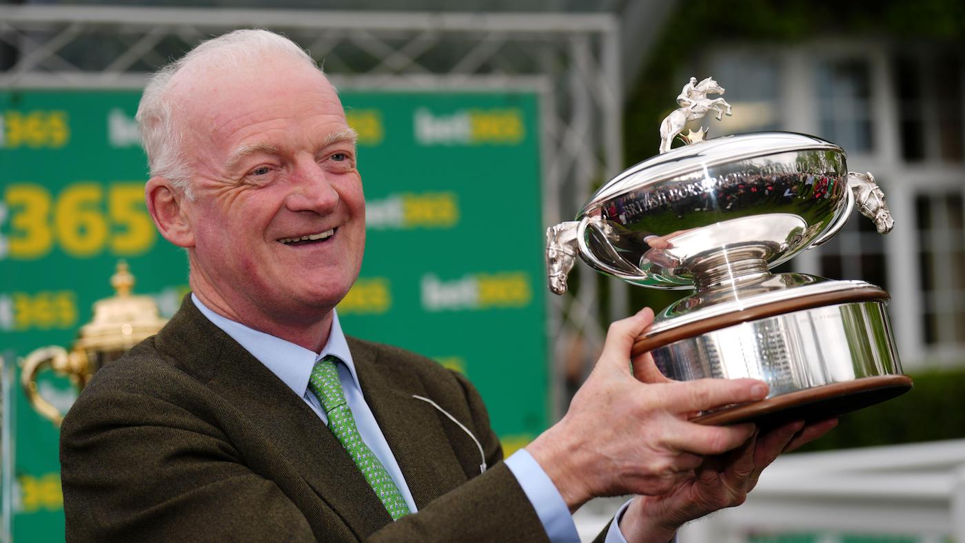 Willie Mullins lifts the champion trainer trophy at Sandown.
