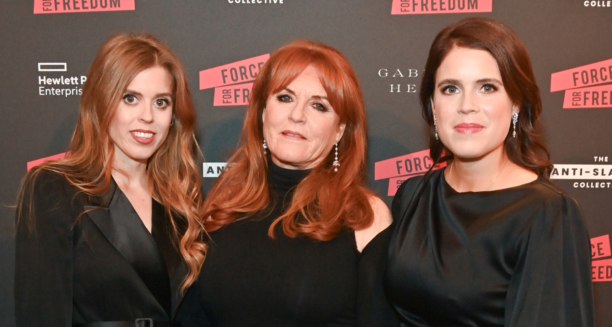 Princess Beatrice, Princess Eugenie and Sarah Ferguson wearing black dresses on a red carpet