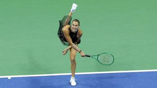 Dressed in black, Aryna Sabalenka hits a serve on court during the US Open 2026