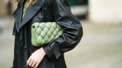 ARIS, FRANCE - FEBRUARY 22: Olesya Senchenko wears a black leather long coat from H&M, a green corduroy jacket from Bagarreuse, a green quilted bag from JW Pei, on February 22, 2021 in Paris, France. (Photo by Edward Berthelot/Getty Images)