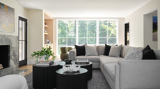 a living room with a large gray couch, black and grey pillows, black coffee tables, and large windows in the background with no window coverings