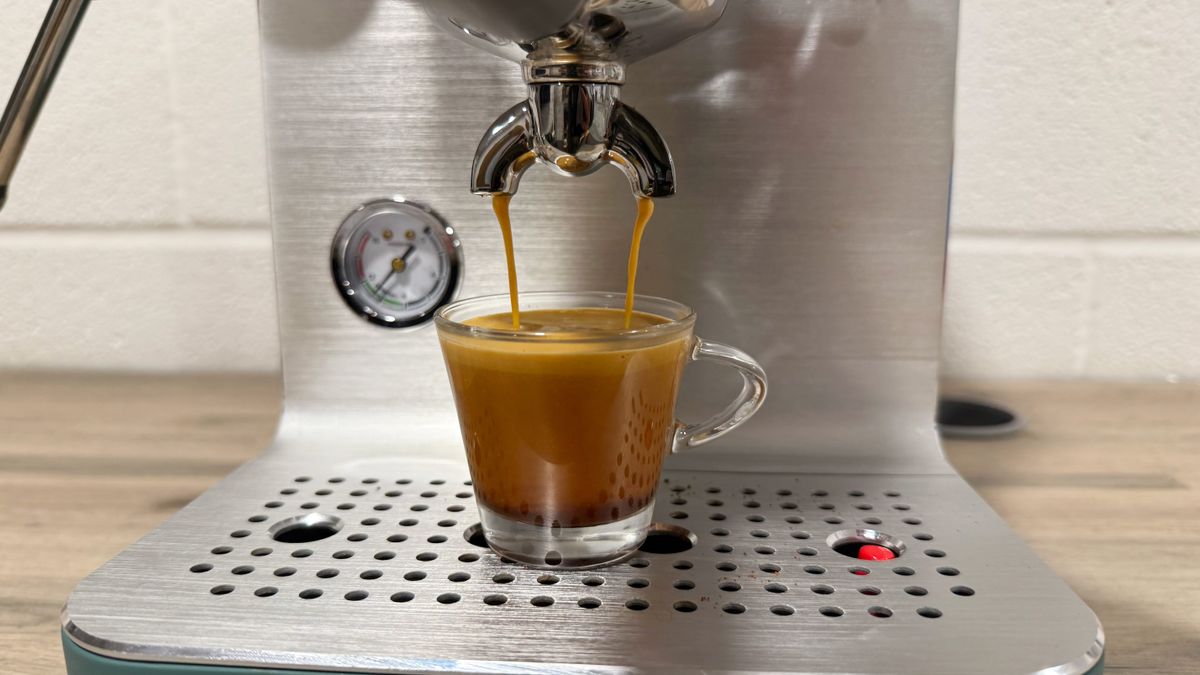 the smeg EMC02 Mini Pro manual espresso machine in action, extracting espresso and steaming milk