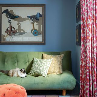 Power blue living room with green sofa and pink and coral pattern curtains