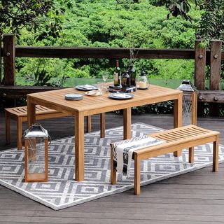 decked area with outdoor dining table and outdoor rug