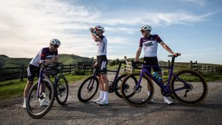 Three riders wearing Mike's Bikes apparel with their bikes