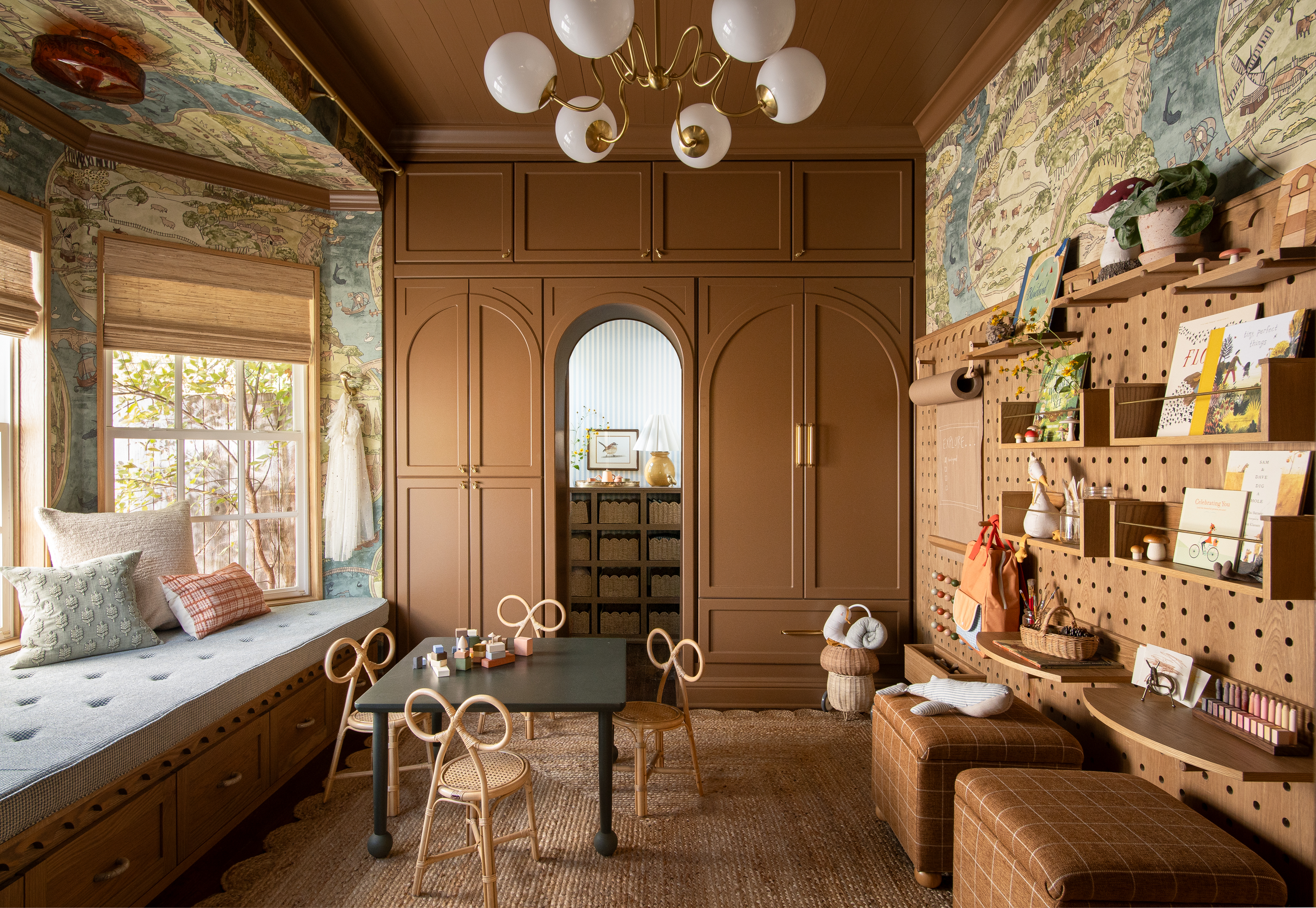 Nursery with brown ceiling and painted cabinets, shelving, stools, window seat and large pendant