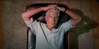 Anthony Bourdain lays down and stares into the camera in a scene from 'Roadrunner'