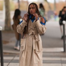 Hanna Lhoumea seen wearing a shoulder free trenchcoat and givenchy sunglasses, outside Victoria/Tomas during Paris Fashion Week