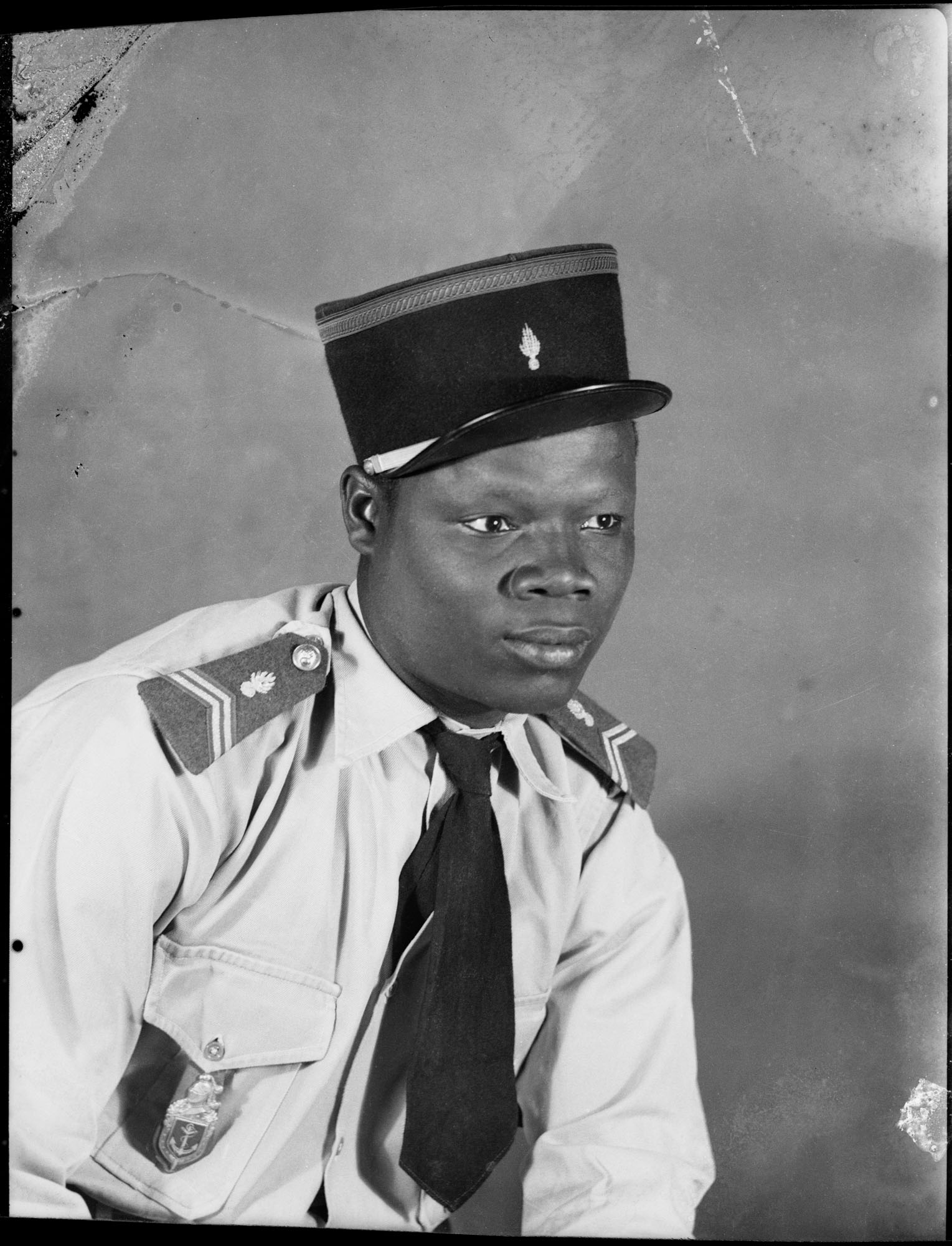 black and white portrait of a man in uniform, by Seydou Keïta