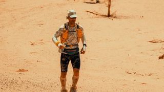 Ultra runner Jon Shield runs through a desert landscape.