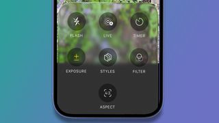 An iPhone on a green and blue background showing the iOS 26 Camera app