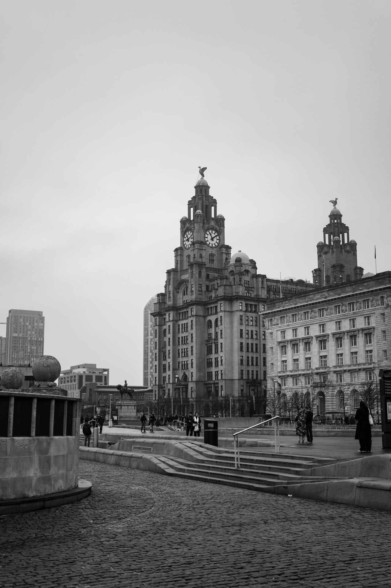 Street leading to the Liver Building in Liverpool against a cloudy sky