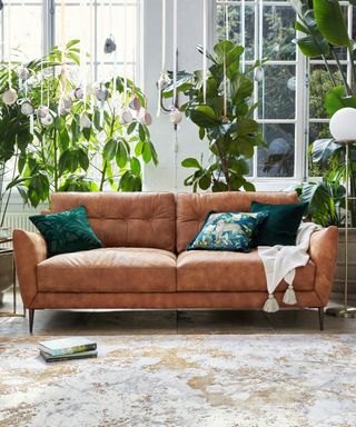 A living room with brown sofa idea with green patterned cushions and cream throw