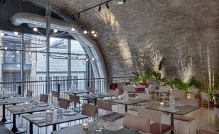 Bala Baya restaurant with arched exposed brick ceiling, chrome and leather stools, palm fronds