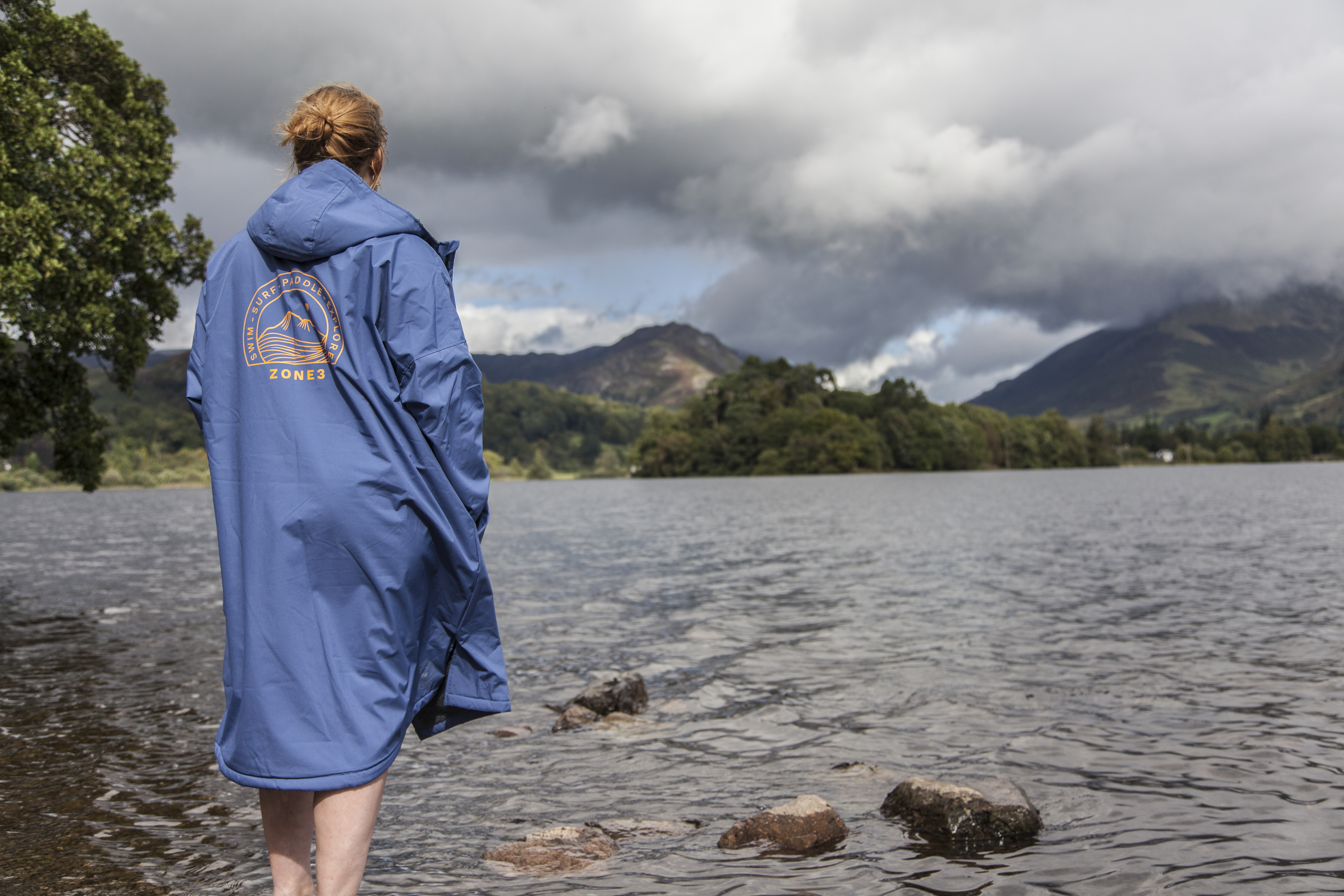Woman standing in Grasmere lake wearing Zone3 thermotech changing robe