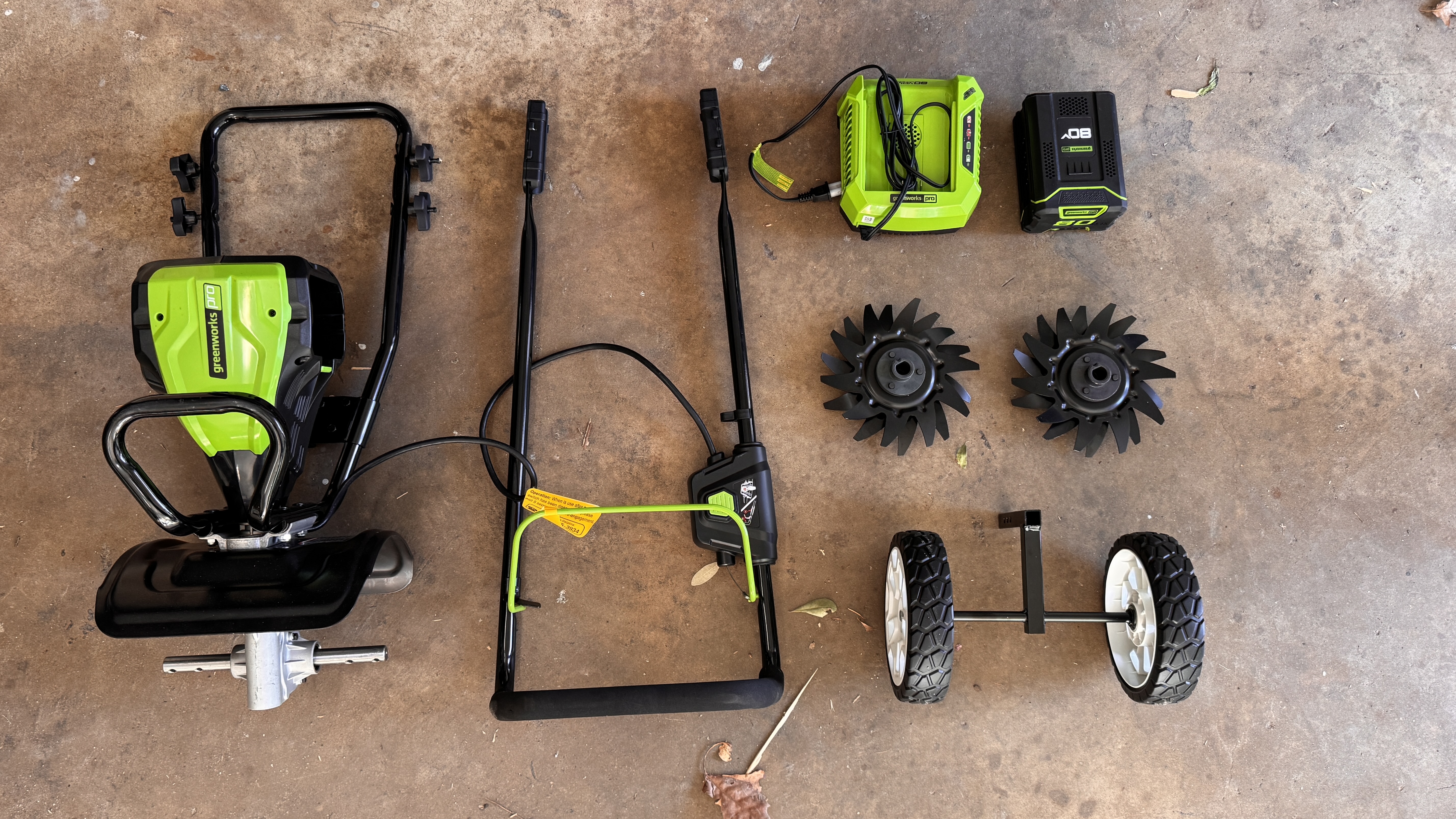 GreenWorks tiller unassembled on garage floor