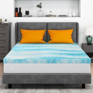 IULULU Mattress Topper on a bed with orange pillows.