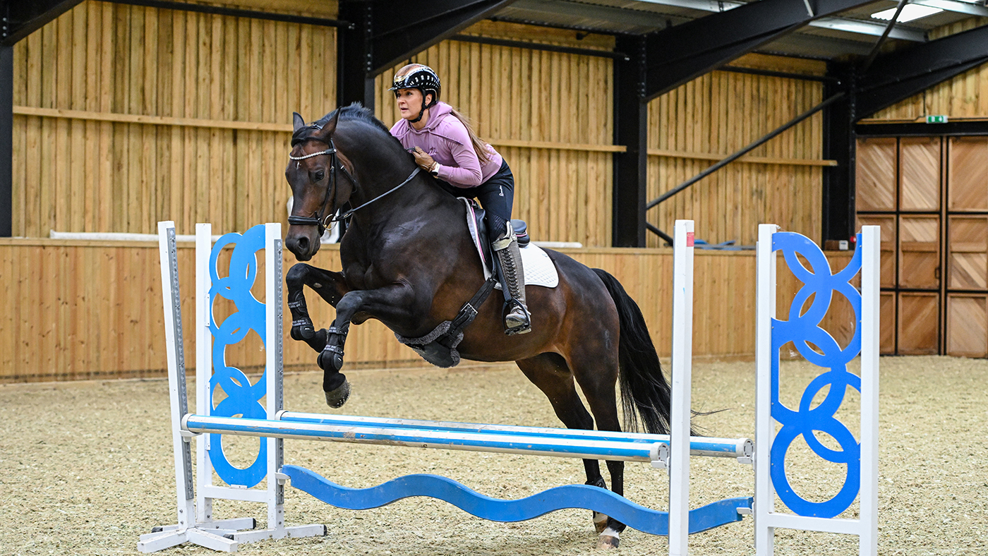 Abi Lye jumps a small fence at home in the indoor school on Francesca II (Jesse).