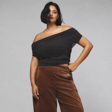 model wears off the shoulder polka dot top and brown barrel leg pants