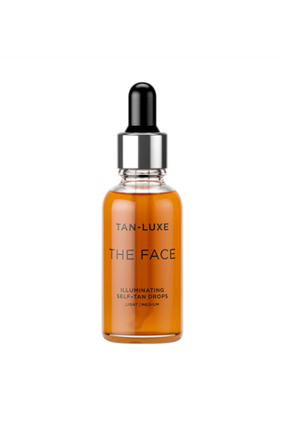 A glass bottle of TAN-LUXE THE FACE self tanning drops against a white background.