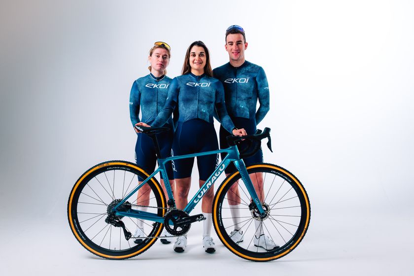 Lauren Molengraaf, H&eacute;l&egrave;ne Clauzel and Ryan Kamp wearing the new teal-coloured Team Eko&iuml; kit standing behind a matching Colnago cyclocross bike