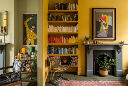 color co-ordinated book on the bookshelf of a yellow living room