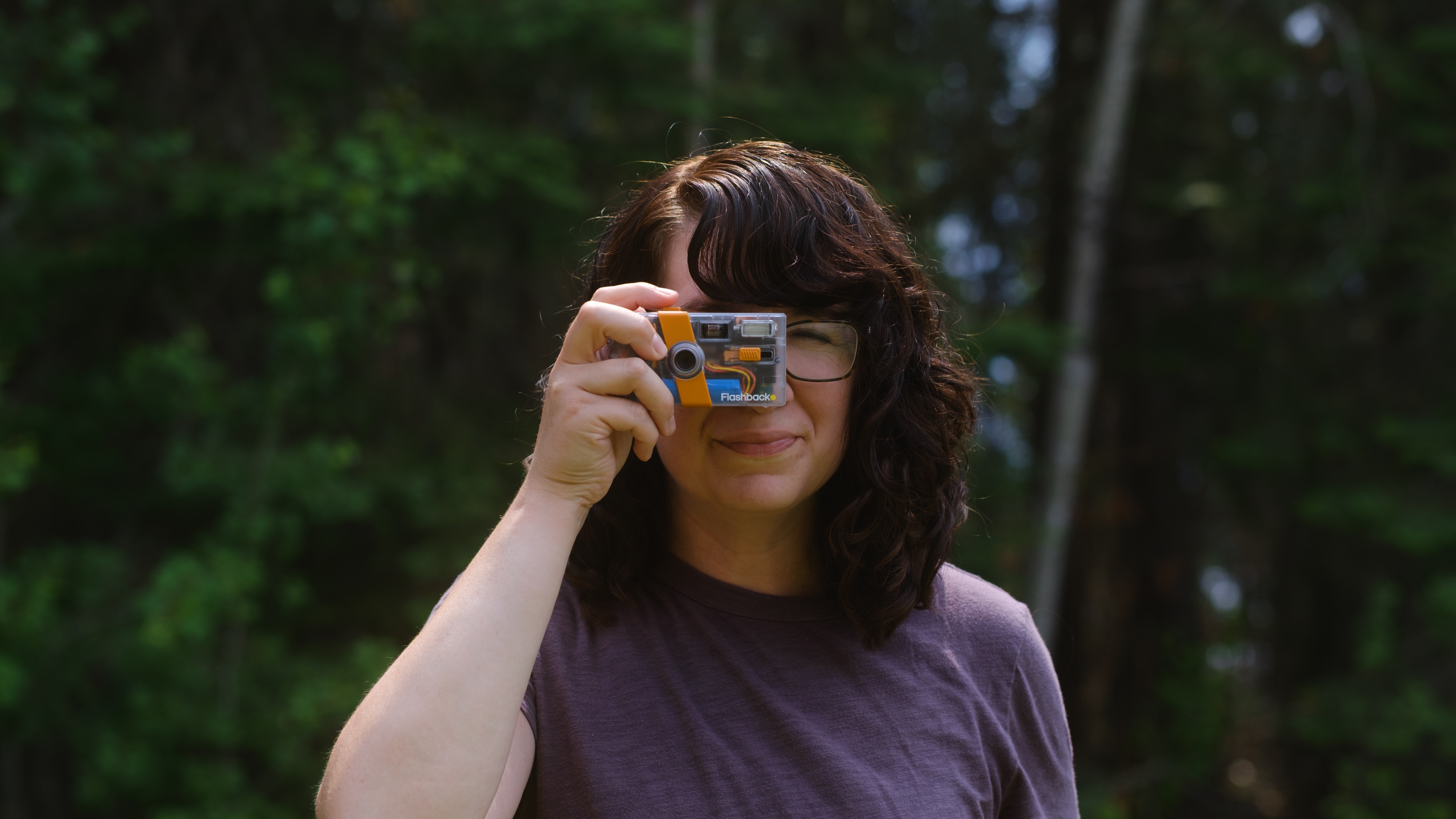 A photographer holds a screen-free digital camera