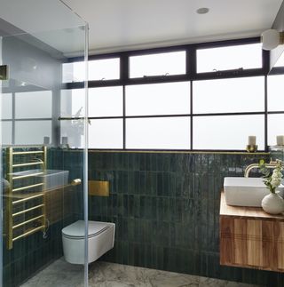 Bathroom with green wall tiles and wooden floating vanity unit