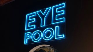 The entrance to the EYEPOOL exhibit alit in neon blue letters.