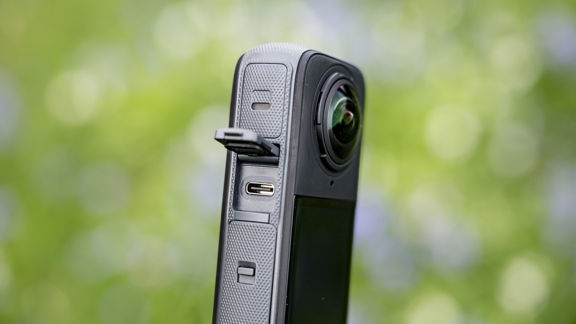 USB-C port of the Insta360 X4 360 degree camera outdoors with vibrant grassy background