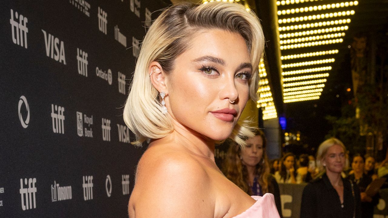 Florence Pugh has a blonde bob with darker roots, and wears a pink strapless dress on the red carpet