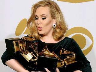 Adele holds her Grammy awards in her arms
