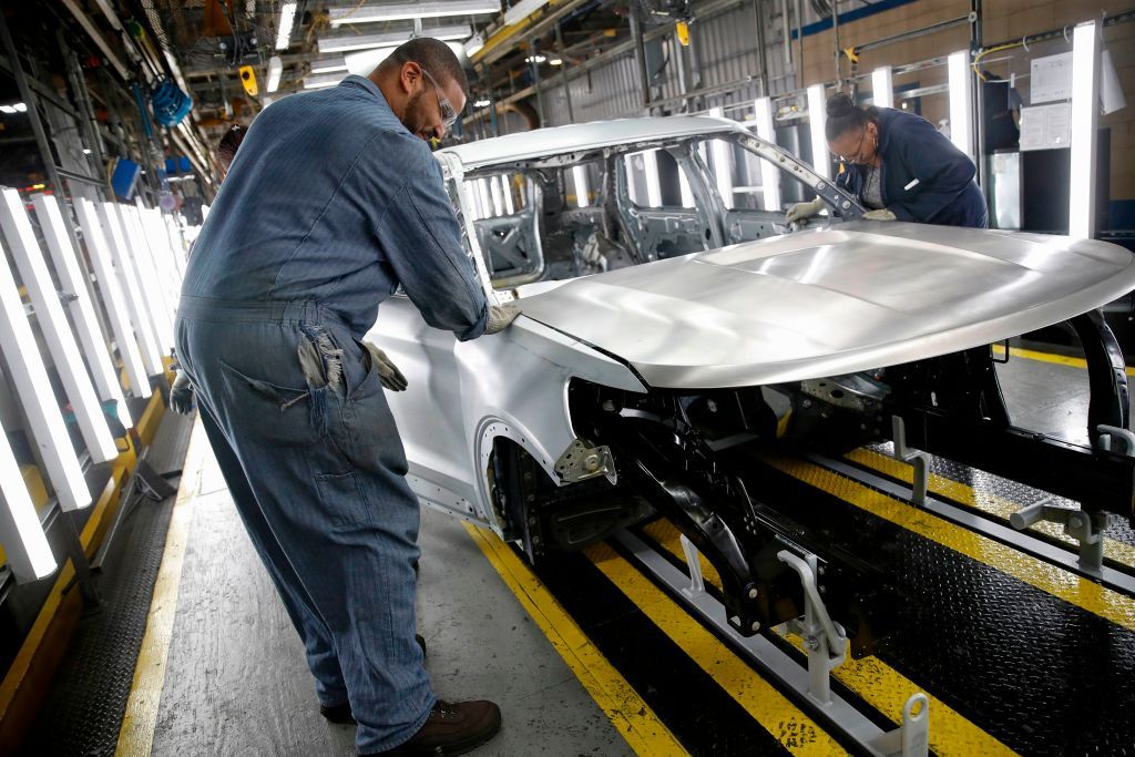 Workers build a Ford car.