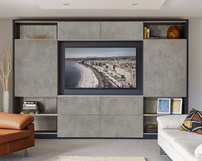 A bedroom TV idea with sliding grey cabinet doors as part of a wall storage unit 