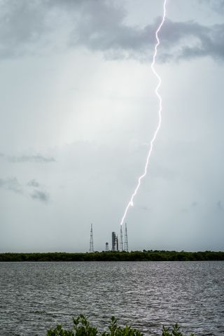 lightning striking a launch tower as seen from a far distance