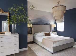 Modern bedroom with dark blue walls and mountain scape wallpapered feature walll