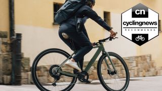 Orbea Vibe electric bike being ridden in front of a tan wall