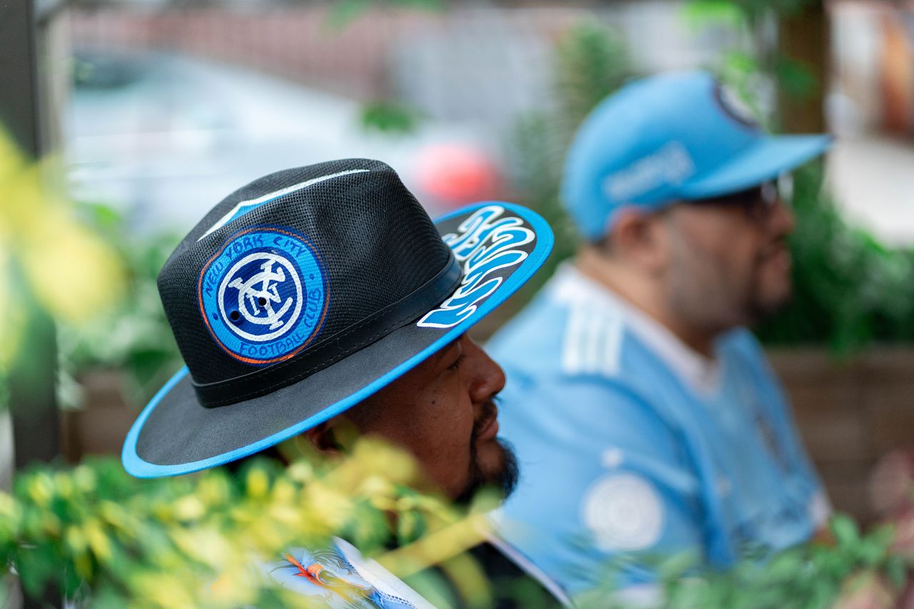 A New York City FC fan wearing a customised panama hat outside a restaurant in Queens