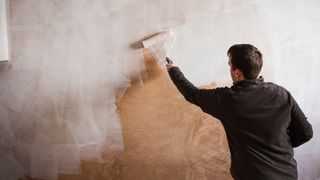 How to paint a room man applying mist coat